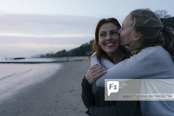 Deutschland  Hamburg  Mutter und Teenager umarmen sich abends am Strand am Elbufer