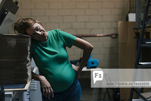Überwältigte schwangere Frau zieht im Bürokeller komische Gesichter