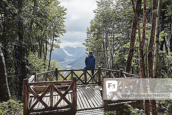 Chile Chaiten Parque Pumalin Mann sitzt auf der Aussichtsplattform und schaut auf den Gletscher
