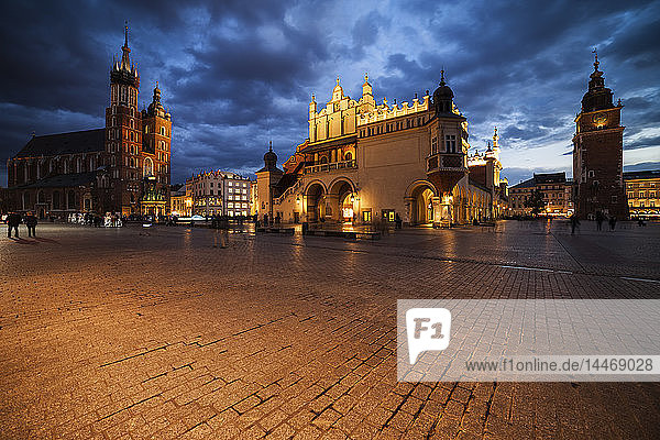 Polen Krakau Hauptplatz in der Altstadt in der Abenddämmerung mit Marienkirche Tuchhalle und Rathausturm
