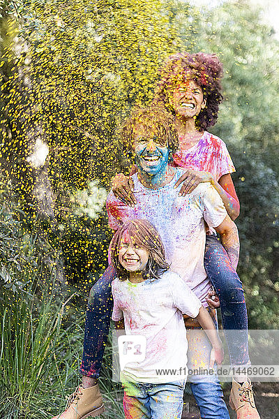 Familie voller bunter Pulverfarbe  feiert Holi  Fest der Farben