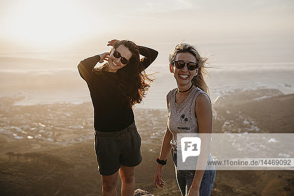 Südafrika  Kapstadt  Kloof Nek  Porträt von zwei glücklichen Frauen bei Sonnenuntergang