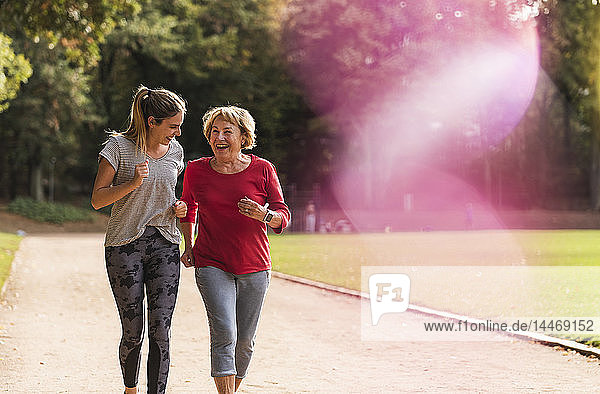 Enkelin und Großmutter amüsieren sich  joggen gemeinsam im Park