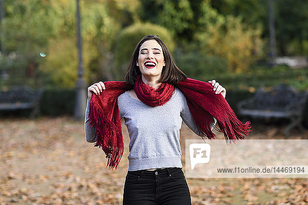 Porträt einer lachenden jungen Frau  die im Herbst ein rotes Tuch trägt