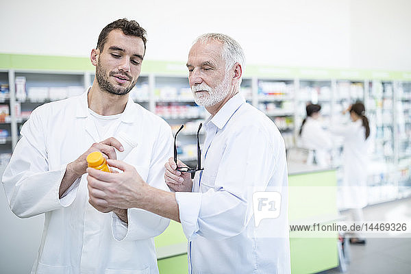 Two pharmacists examining medicine in pharmacy