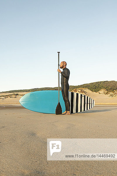 Spain  Andalusia  Tarifa  man with stand up paddle board on the beach