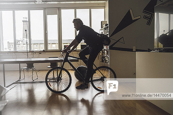 Mann betritt Büro mit seinem Fahrrad