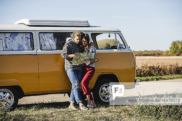 Couple on a road trip in their camper  looking at map