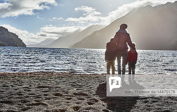 Argentina  Patagonia  Lago Nahuel Huapi  woman with two sons standing at the shore overlooking the lake