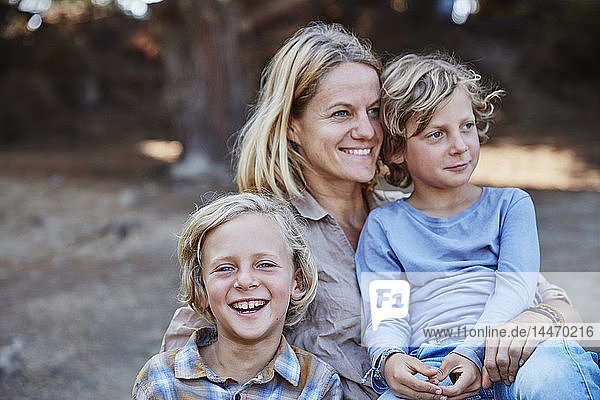 Porträt einer glücklichen Mutter mit zwei Söhnen im Freien