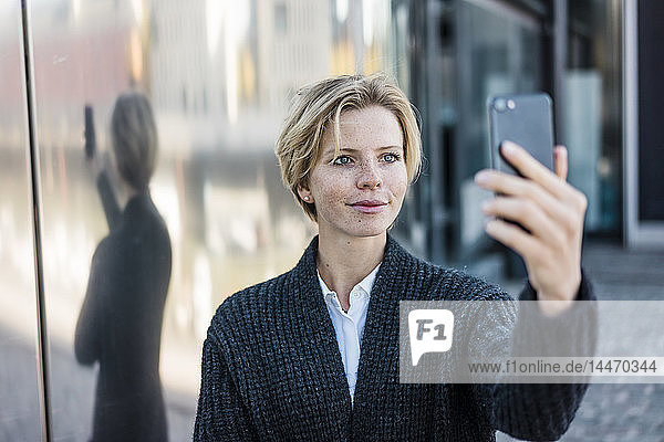 Young businesswoman taking selfie with her smartphone
