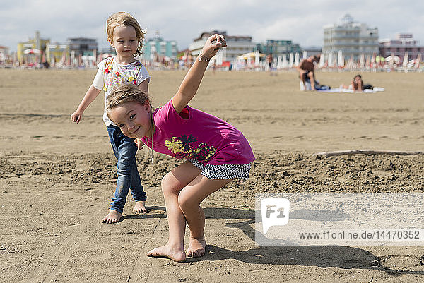 Zwei verspielte kleine Mädchen am Strand
