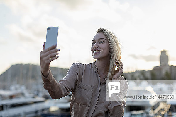 Smiling young woman taking a selfie at the waterfront