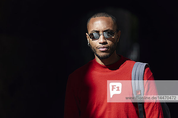 Portrait of young man wearing sunglasses and red pullover