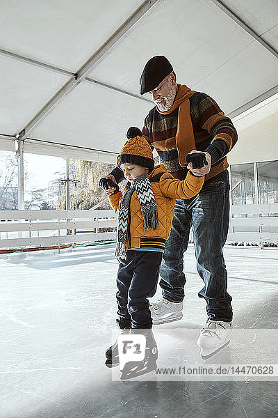 Grossvater und Enkel auf der Eisbahn  Schlittschuhlaufen