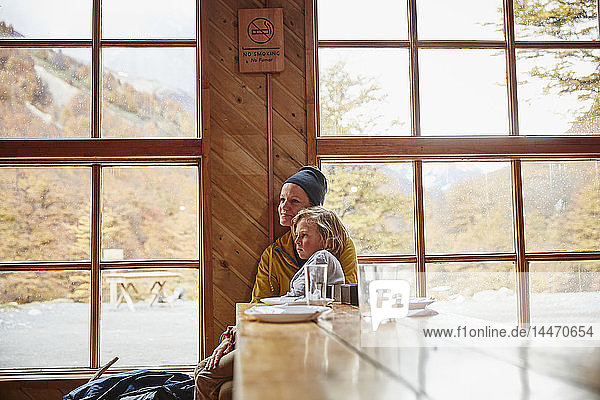 Chile  Torres del Paine Nationalpark  Mutter mit Sohn in einer Berghütte am Tisch sitzend