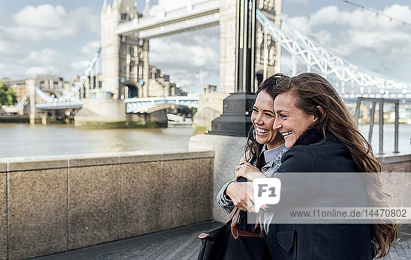 UK, London, two happy women near the Tower Bridge