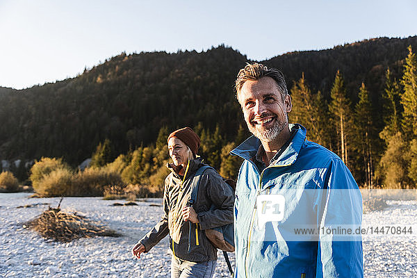 Mature couple hiking at riverside in the evening light