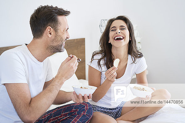 Glückliches Paar beim Frühstück im Bett