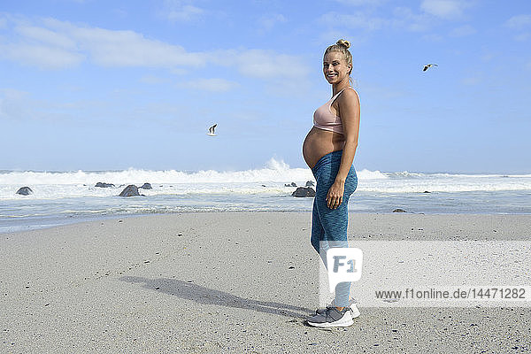 Aktive schwangere Frau am Strand