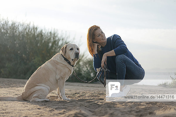 Deutschland  Hamburg  Frau mit Hund am Strand am Elbufer