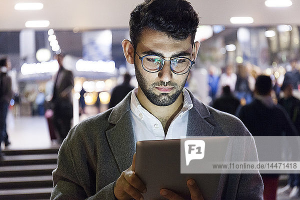 Germany  Munich  portrait of young businessman using digital tablet at central station