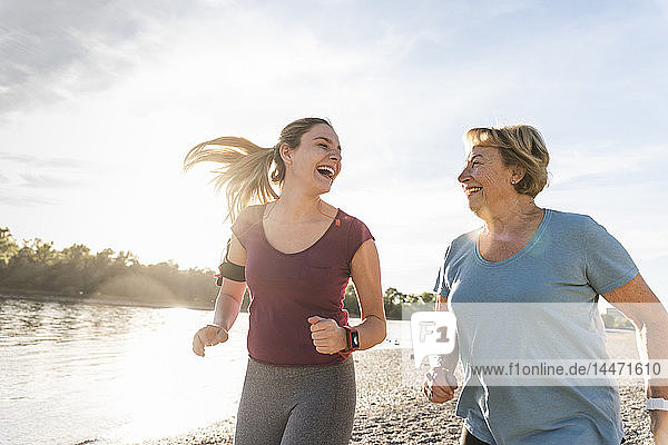 Enkelin und Großmutter amüsieren sich  joggen gemeinsam am Fluss