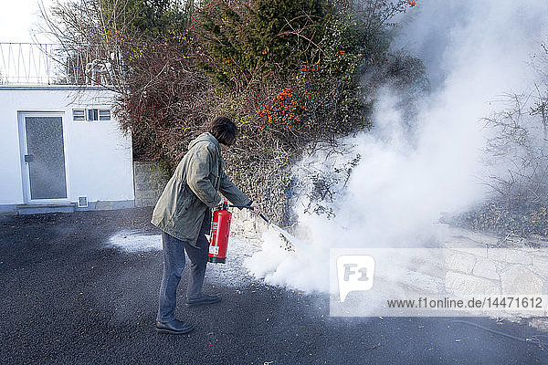 Man extinguishing cable fire in garden near the house