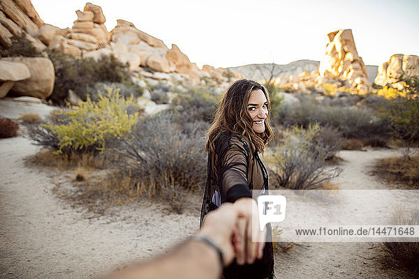 USA  California  Los Angeles  portrait of smiling woman walking hand in hand in Joshua Tree National Park