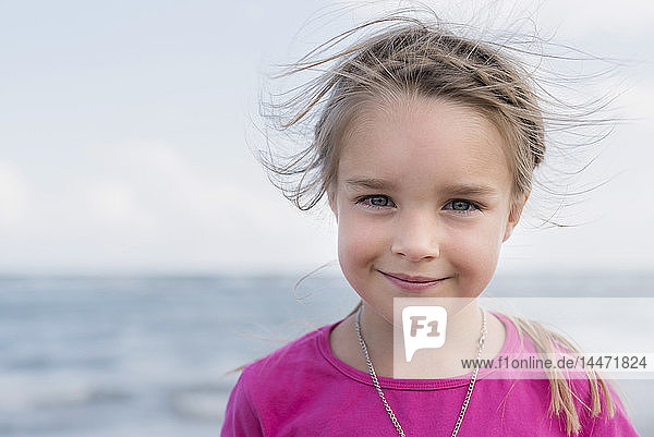 Porträt eines lächelnden kleinen Mädchens am Meer