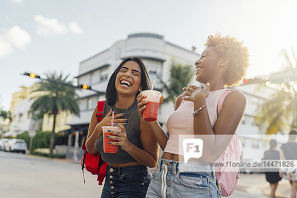 USA  Florida  Miami Beach  two happy female friends having a soft drink in the city