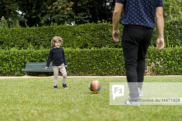 Vater und Sohn spielen im Park Fussball