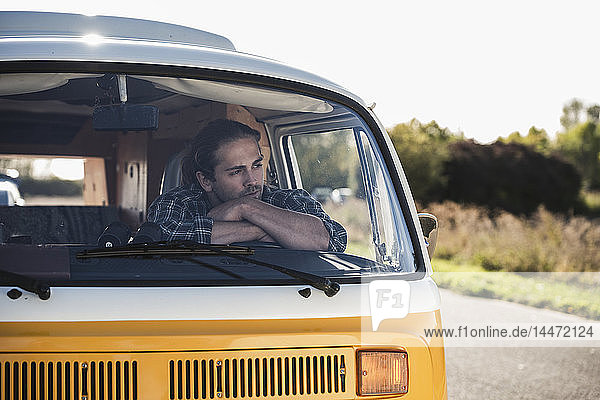 Young man on a road trip with his camper  taking a break  relaxing