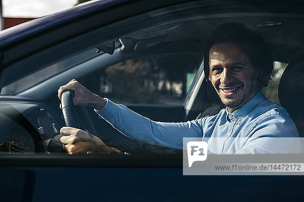 Portrait of smiling businessman driving car