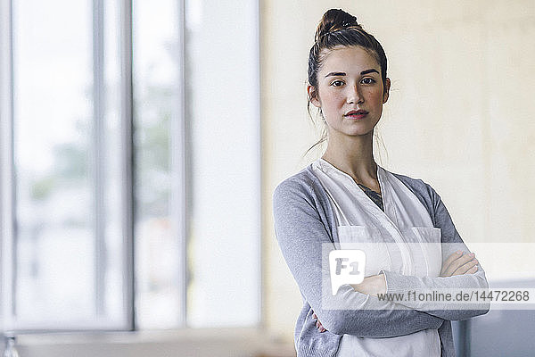 Portrait of a beautiful young woman  standing in office  with arms crossed