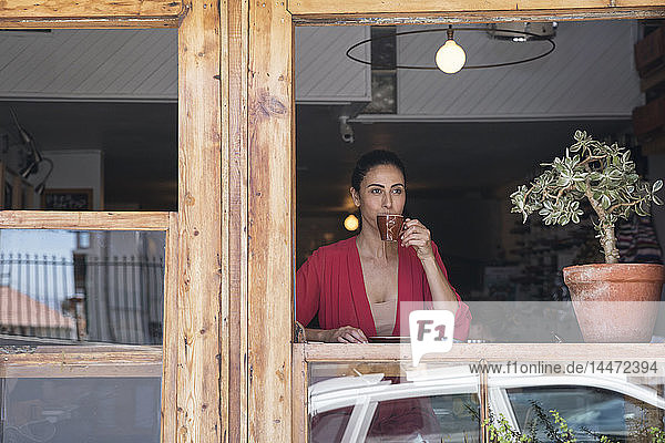 Reife Frau sitzt im Café und trinkt Kaffee