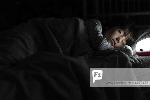 Girl sleeping in bed at night with night light