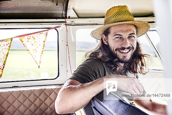 Porträt eines glücklichen jungen Mannes in einem Lieferwagen