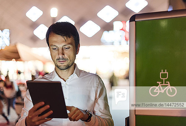 Businessman using digital tablet next to charging station
