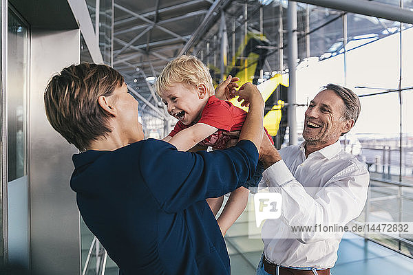 Kleiner Junge freut sich über die Ankunft seiner Geschäftsmutter am Flughafen