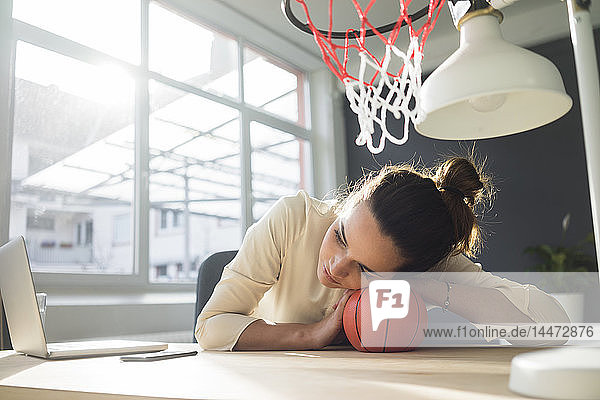 Freiberufler entspannt sich mit Basketball am Schreibtisch in einem Loft