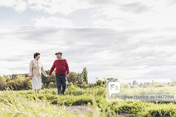 Älteres Ehepaar bei einem Spaziergang in ländlicher Landschaft