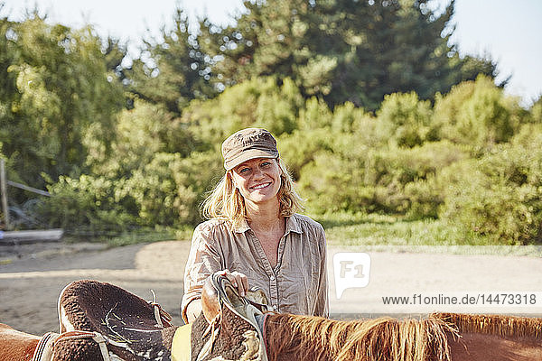 Porträt einer lächelnden Frau mit einem Pferd
