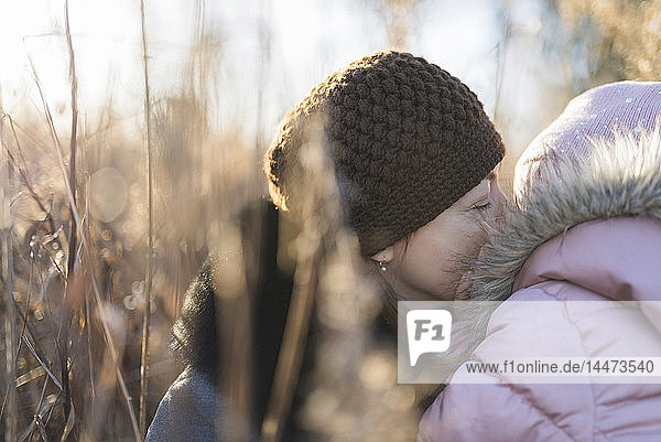 Frau und ihre kleine Tochter auf der Herbstwiese zur goldenen Stunde