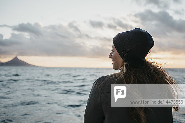 South Africa  young woman with woolly hat during boat trip at sunset