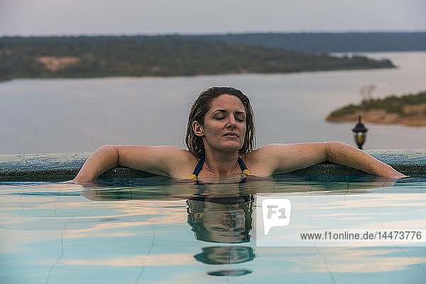 Afrika  Uganda  Queen-Elizabeth-Nationalpark  Frau entspannt sich in einem Pool über dem Kazinga-Kanal