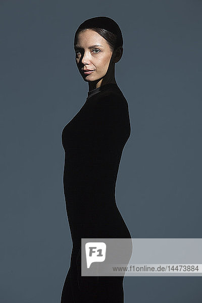 Bildnis einer schlanken  schwarz gekleideten Frau mit Schlaghose im Gesicht