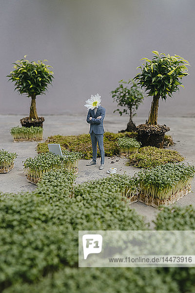 Geschäftsmann-Figur mit Blumenkopf stehendem Park
