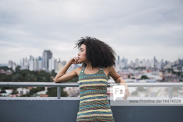 Panama  Panama City  nachdenkliche junge Frau auf dem Balkon  die in die Ferne schaut