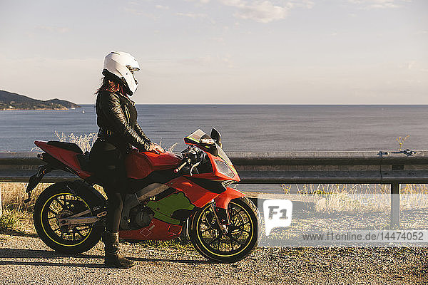 Italy  Elba Island  female motorcyclist at viewpoint